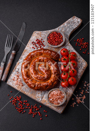 Delicious homemade sausage in the form of a spiral baked on the grill with salt, spices Delicious homemade sausage in the form of a spiral baked on the grill with salt, spices 115183407