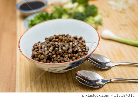 Cutting board with raw japanese buckwheat pasta and lentils 115184315