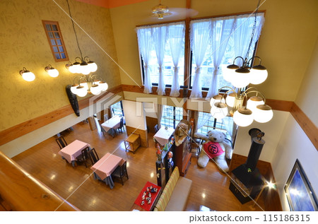 A warm dining room with bright windows and wooden furniture A warm dining room with bright windows and wooden furniture 115186315