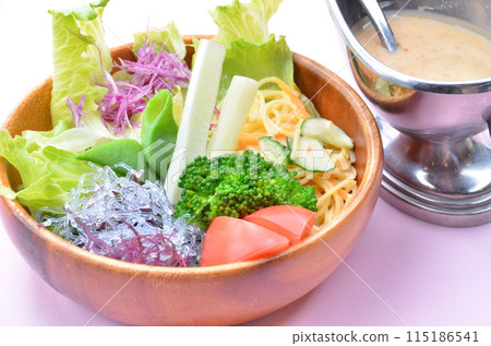 Healthy salad bowl with plenty of vegetables and special dressing 115186541