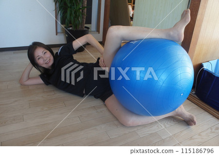 Tall woman riding a balance ball 115186796