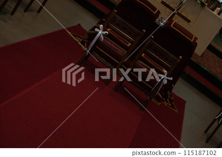 Church interior with ornate chairs, red carpet, spiritual significance and peaceful contemplation 115187102