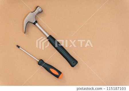 Hammer and screwdriver on a wooden background with copy space. Carpentry concept 115187103