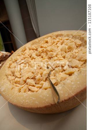 Wheel of Parmesan Cheese Chunks served with a Scoop, an Italian gourmet delicacy Wheel of Parmesan Cheese Chunks served with a Scoop, an Italian gourmet delicacy 115187108