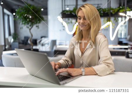 Woman freelancer using laptop in cafe writing notes doing internet project Woman freelancer using laptop in cafe writing notes doing internet project 115187331