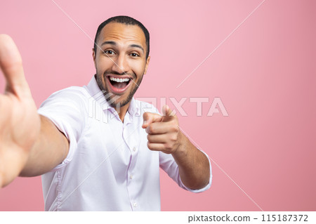 Excited man in white shirt making selfie pointing at you 115187372