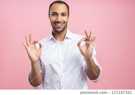 Approved man in white shirt showing ok gesture with both hands Approved man in white shirt showing ok gesture with both hands 115187382