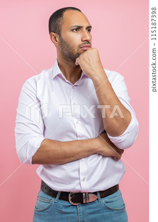 Thoughtful man in white shirt holding chin having pensive face 115187398