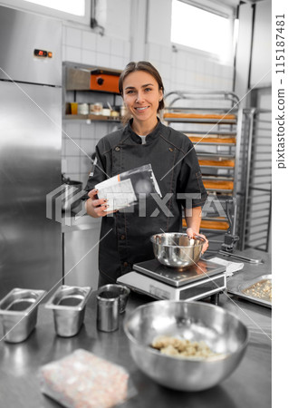 Experienced chef in professional kitchen preparing dough with flour to make bread 115187481