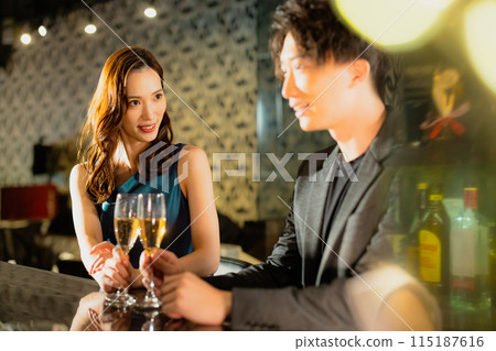 Men and women drinking at a bar 115187616