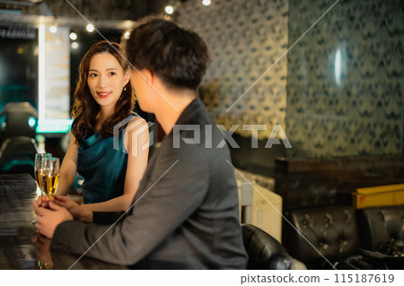 Men and women drinking at a bar 115187619