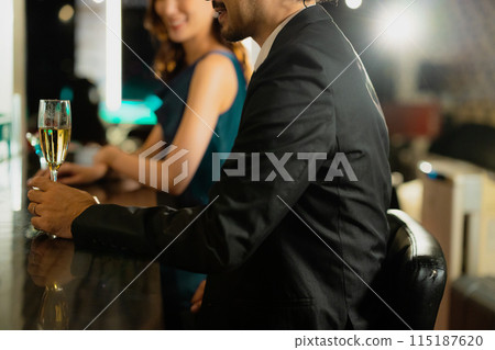 Men and women drinking at a bar 115187620