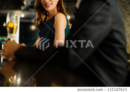 Men and women drinking at a bar 115187623