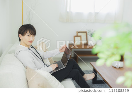 看一台個人計算機的一個年輕人在客廳 115188259