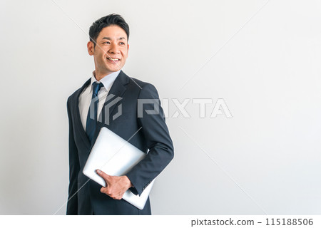 身穿西裝、配有電腦/筆記型電腦的中年亞洲商人 身穿西裝、配有電腦/筆記型電腦的中年亞洲商人 115188506