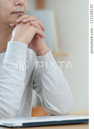 A man thinking with his laptop closed A man thinking with his laptop closed 115189135