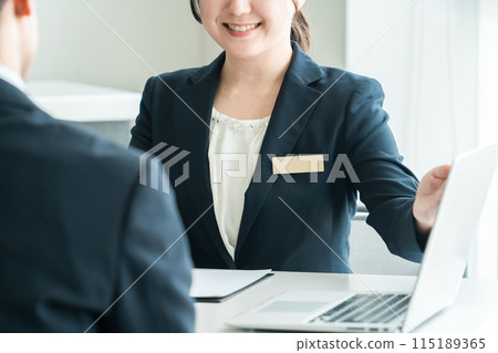 Business woman using a computer to discuss business and explain products (real estate/planning) 115189365