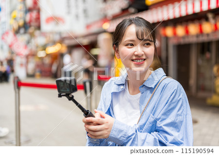 Young and pretty woman taking a selfie in the city's downtown area | Osaka Tourism Image | Dotonbori Shopping Street, Osaka City, Osaka Prefecture 115190594