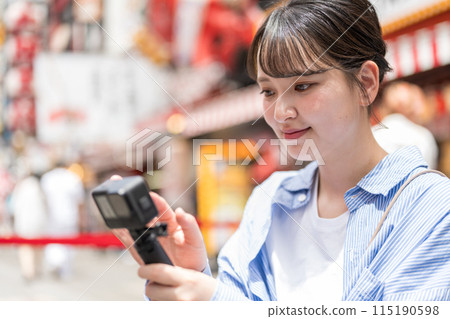 Young and pretty woman taking a selfie in the city's downtown area | Osaka Tourism Image | Dotonbori Shopping Street, Osaka City, Osaka Prefecture 115190598