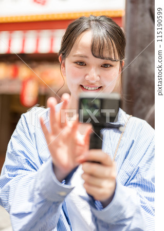 Young and pretty woman taking a selfie in the city's downtown area | Osaka Tourism Image | Dotonbori Shopping Street, Osaka City, Osaka Prefecture 115190599