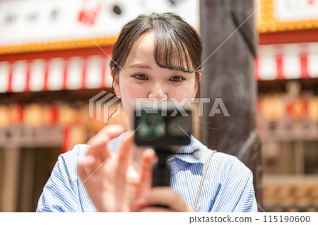 Young and pretty woman taking a selfie in the city's downtown area | Osaka Tourism Image | Dotonbori Shopping Street, Osaka City, Osaka Prefecture Young and pretty woman taking a selfie in the city's downtown area | Osaka Tourism Image | Dotonbori Shopping Street, Osaka City, Osaka Prefecture 115190600