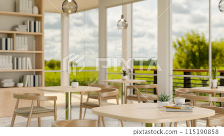 A minimalist contemporary coffee shop indoor seating area features a view of a green field outside. 115190858