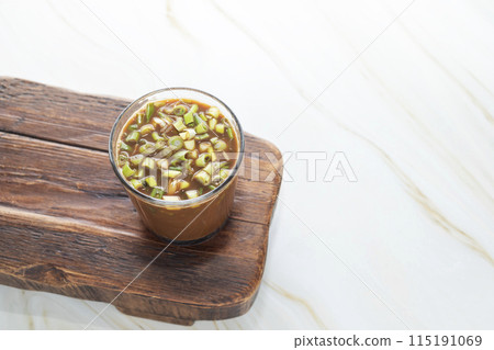 Spring Onion Coffee Or Scallion Coffee on Wooden Tray. Popular Beverage In China. Top View Glass Of Drink, Cappuccino Or Latte With Onions On Granite Table. Copy Space. Horizontal Plane. 115191069