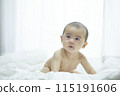 Baby lying on bed 115191606