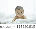Baby lying on bed 115191615