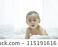 Baby lying on bed 115191616