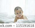 Baby lying on bed 115191618