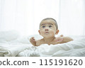 Baby lying on bed 115191620