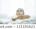Baby lying on bed 115191621