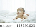 Baby lying on bed 115191623