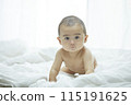 Baby lying on bed 115191625