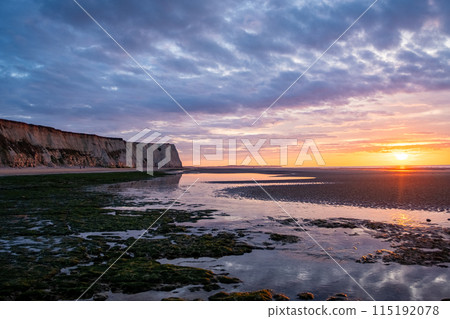 Stunning Sunset Along the Cliffs at Low Tide showcases vibrant colors and a tranquil atmosphere Stunning Sunset Along the Cliffs at Low Tide showcases vibrant colors and a tranquil atmosphere 115192078
