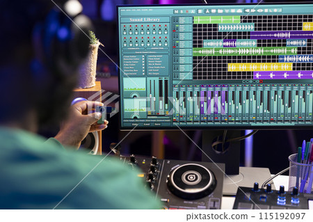 Artist composing new music with an usb stick in his home studio, editing songs from old audio recordings. Skilled songwriter producer mixing and mastering soundtracks, production software. 115192097