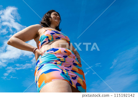 A woman in a bright swimsuit enjoys a sunny day at the bay A woman in a bright swimsuit enjoys a sunny day at the bay 115192142