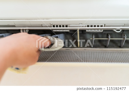 A man cleaning the air conditioner A man cleaning the air conditioner 115192477