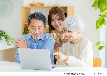 Senior couple and child looking at a computer 115192492