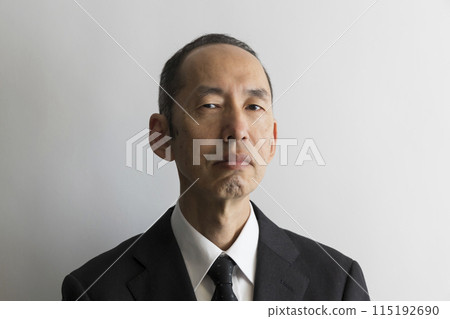 Portrait of a glaring middle-aged Japanese man in a suit Portrait of a glaring middle-aged Japanese man in a suit 115192690