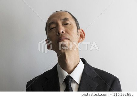 Portrait of a middle-aged Japanese man in a suit glaring from above Portrait of a middle-aged Japanese man in a suit glaring from above 115192693