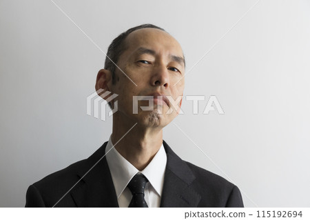 Portrait of a middle-aged Japanese man in a suit glaring from above Portrait of a middle-aged Japanese man in a suit glaring from above 115192694