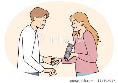 Pregnant woman holding ultrasound picture with baby showing future kiddy to happy father 115192957