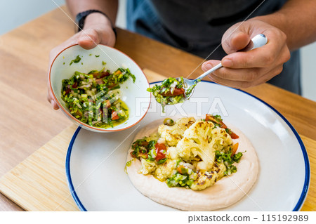 Chef at the kitchen preparing bean porridge with cauliflower and vegetables Chef at the kitchen preparing bean porridge with cauliflower and vegetables 115192989