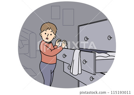 Little boy is standing near closet with clothes, looking at textiles with curiosity 115193011