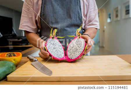Chef cuts and peels dragon fruit on the cutting board 115194481