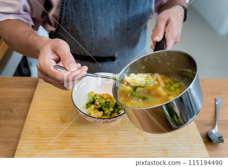 Chef at the kitchen preparing lentils soup with cauliflower and broccoli Chef at the kitchen preparing lentils soup with cauliflower and broccoli 115194490