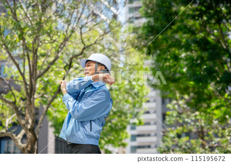 Man in work clothes stretching 115195672