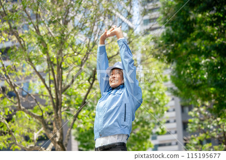 Man in work clothes stretching Man in work clothes stretching 115195677